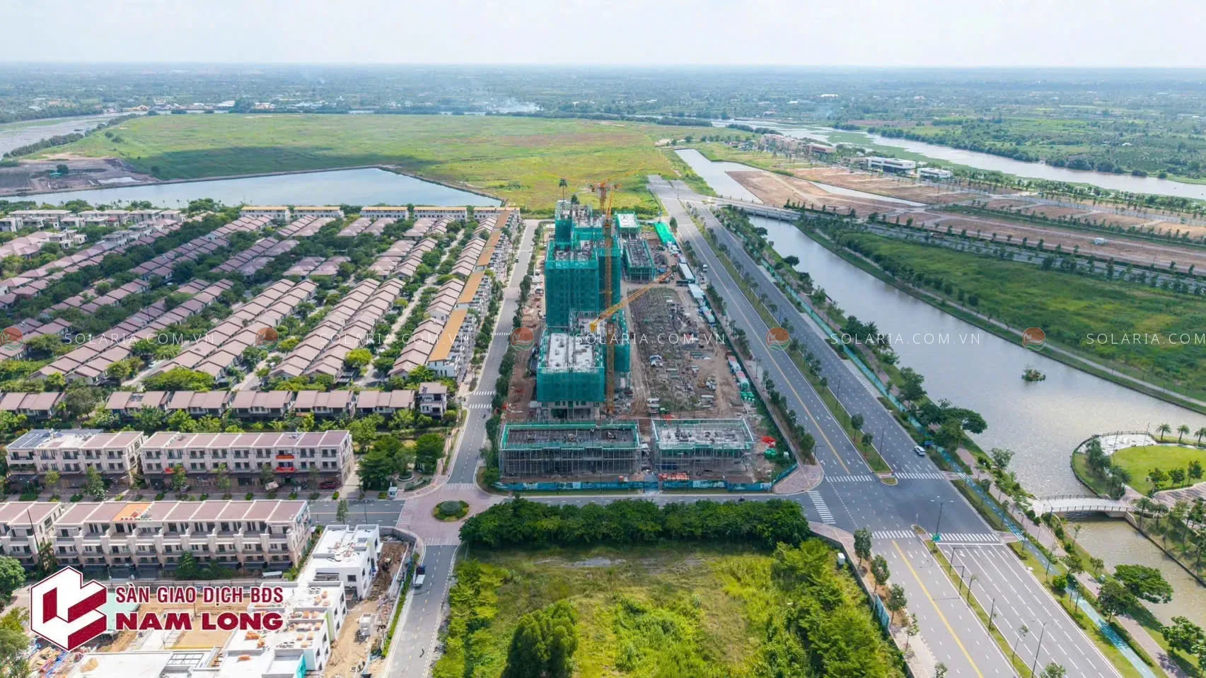 Công trường xây dựng tòa nhà cao tầng gần đại lộ và kênh nước tại khu đô thị Waterpoint